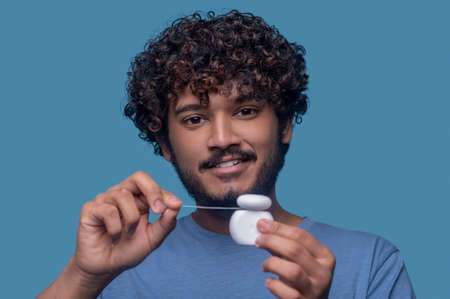 Pleased guy posing for the camera before the flossing procedureの写真素材