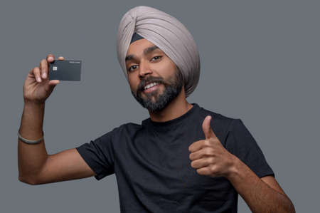 Male cardholder in the turban approving his payment systemの写真素材