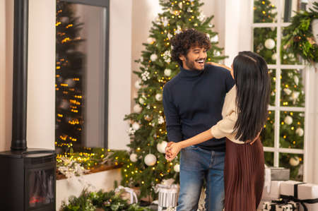 Man dancing with woman indoors with x-mas decorationの写真素材