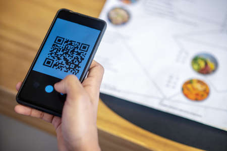 Curly-haired businessman choosing lunch menu and ordering onlineの写真素材