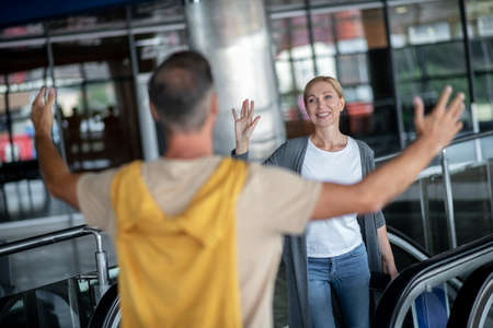 Short-haired guy welcoming a joyous airline passenger