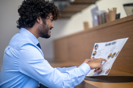 Dark-haired young businessman checking the menu and choosing lunch