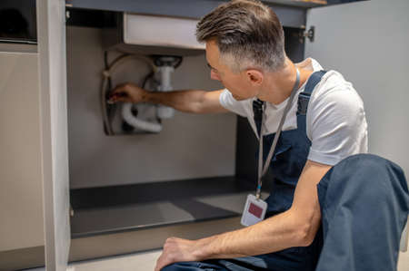 Man putting ball valve on water pipeの写真素材