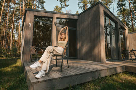 Pretty young blonde woman sitting in a chiar and feeling relaxedの写真素材