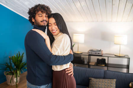 Man hugging woman dancing with closed eyesの写真素材