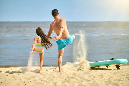 Dad and daughter playing together on the beach