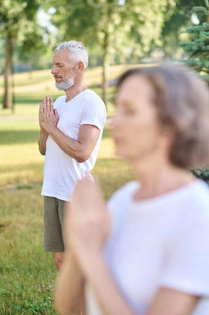 Group of people meditating together in parkの写真素材