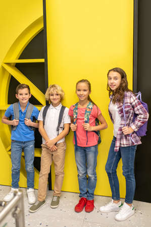 Pleased children in casual clothes standing indoors