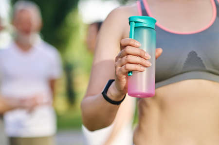 Close up of a woman holding a bottle of waterの写真素材