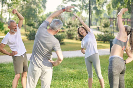 Group of people doing morning exercises in the parkの写真素材