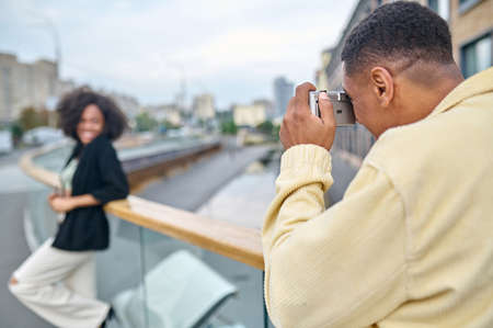 Man with his back to camera photographing woman