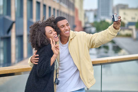 Man taking selfie with woman showing freedom gestureの写真素材