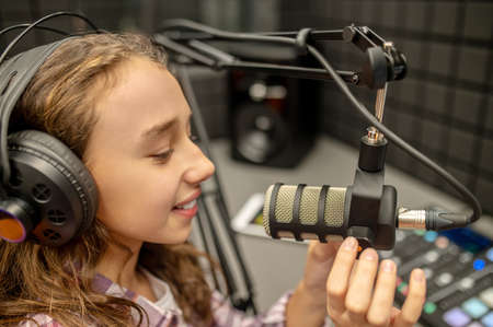 Young RJ broadcasting a program from the radio stationの写真素材