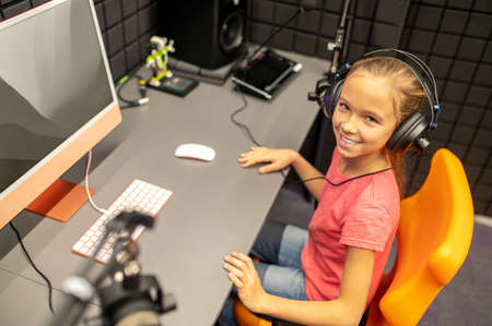 Smiling girl posing for the camera in the broadcasting studioの写真素材