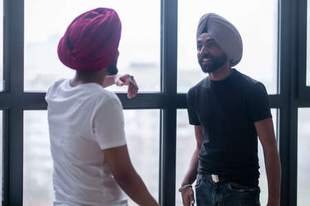 Two men in turbans talking and looking involvedの写真素材