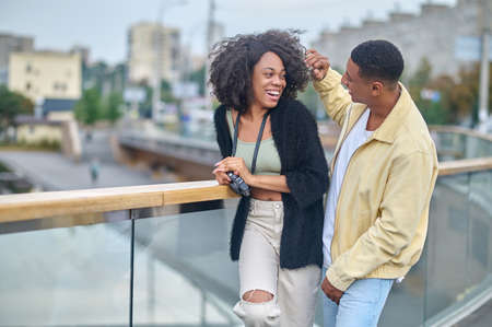 Man touching hair of woman standing on bridgeの写真素材