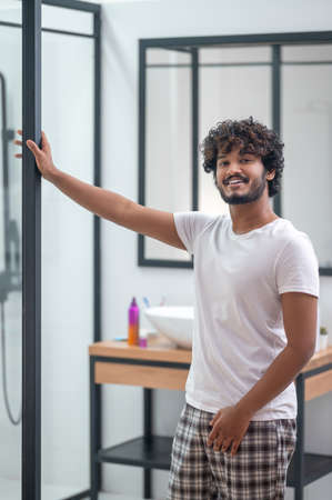 Contented dark-haired guy standing in the bathroomの写真素材
