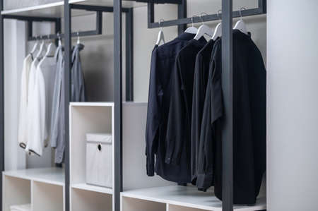 Colorful pieces of clothing arranged in a wooden closet
