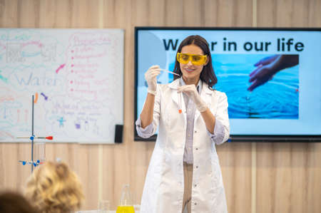Woman showing chemistry experiment to kids in classの写真素材