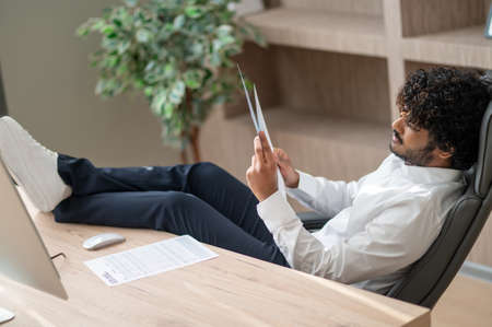 Young indian businessman sitting in the chair in the office
