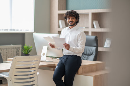 Young curly-haired manager feeling busy at work