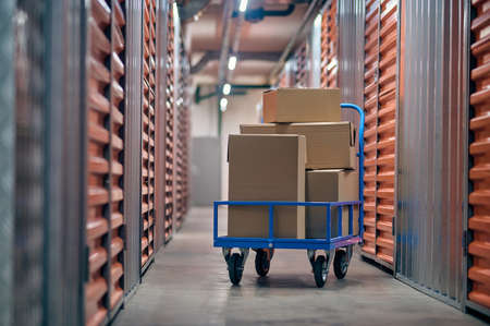 Stacked boxed goods lying on the hand truckの写真素材