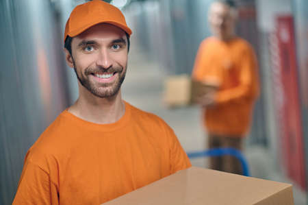 Cheerful young worker working with his colleague in the warehouseの写真素材
