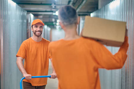 Two warehouse loaders working in the storage roomの写真素材