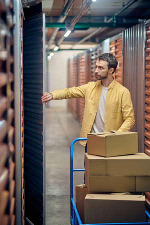 Focused male order picker picking ordered goods