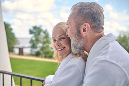 A couple at the balcony hugging and feeling amazingの写真素材