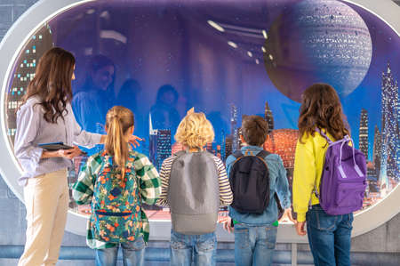 Back view of children and teacher looking at screenの写真素材