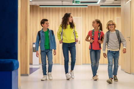 Schoolchildren with backpacks walking in corridorの写真素材