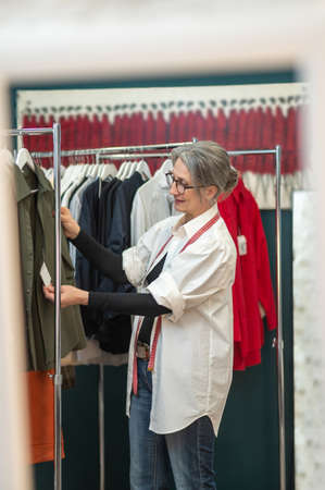 Woman looking touching price tag on blouse