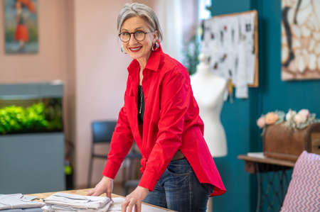 Woman standing near table smiling at camera