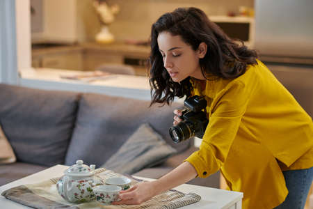 Young female photographer with camera in handsの写真素材