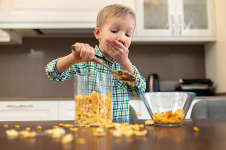 Scared kid adding oatmeal ingredients to a glass bowl