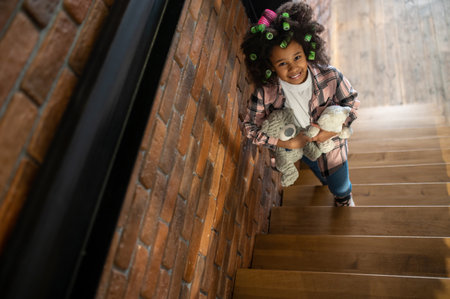 Top view of girl with toys standing on stairsの写真素材