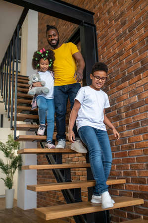 Bottom view of man with children descending stairsの写真素材