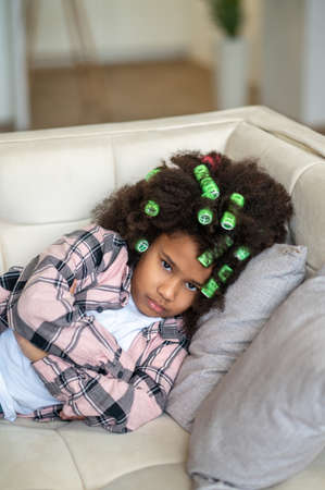 African american girl lying on couch looking at camera