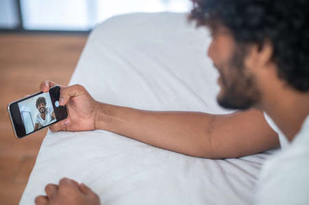 Male taking a selfie in the bedroomの写真素材