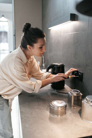 A housewife doing repair works in the kitchenの写真素材