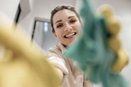 Close up picture of a smiling woman in yellow glovesの写真素材