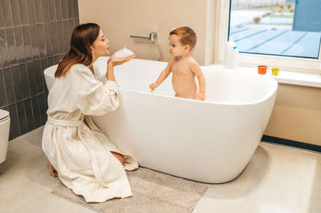 Parent playing with her little child in the bathroom