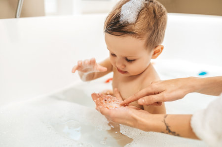 Cute male child sitting in the bathtub