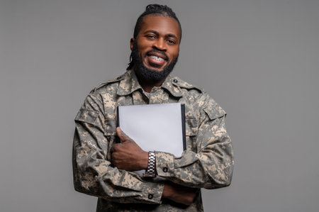 Joyful military man with documents looking aheadの写真素材