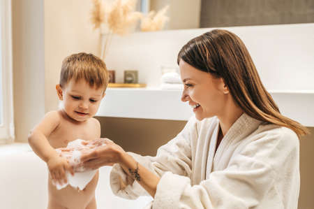 Happy mother playing with her baby in the bathroomの写真素材