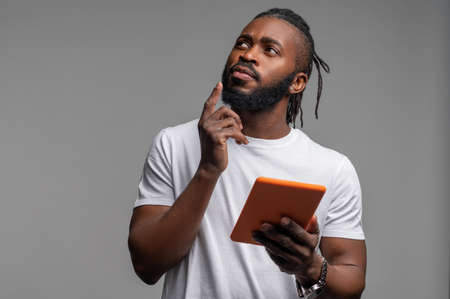 Thoughtful young man looking up at the ceilingの写真素材