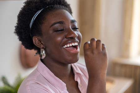 Young african woman taking vitamins and smiling