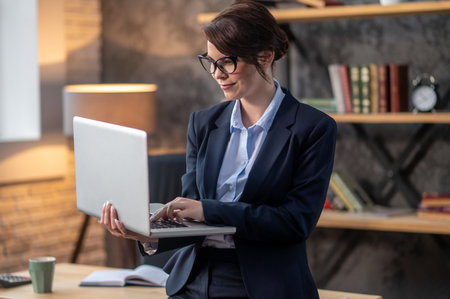 Elegant dark-haired woman with a laptop in handsの写真素材