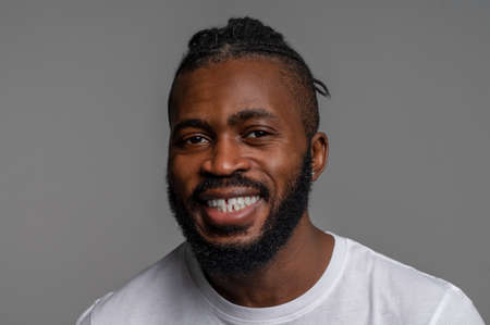 Smiling male posing for the camera against the gray background